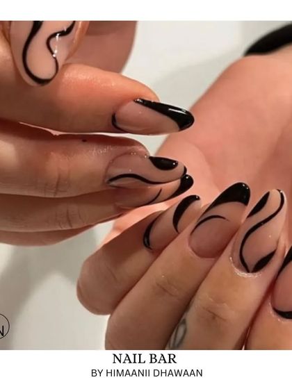 Negative space nail art with bold black swirls on a clear extension, creating a very modern and edgy look.