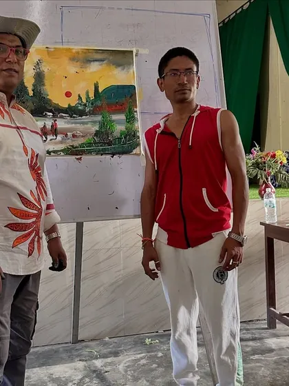 Posing with a completed landscape painting after a workshop at Gogamukh College Auditorium in Dhemaji.