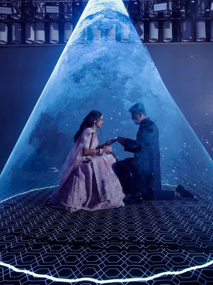A truly magical proposal moment during the Sangeet, with the couple illuminated by a single spotlight under a ceiling of thousands of blue LED lights, creating the illusion of a starry night sky.