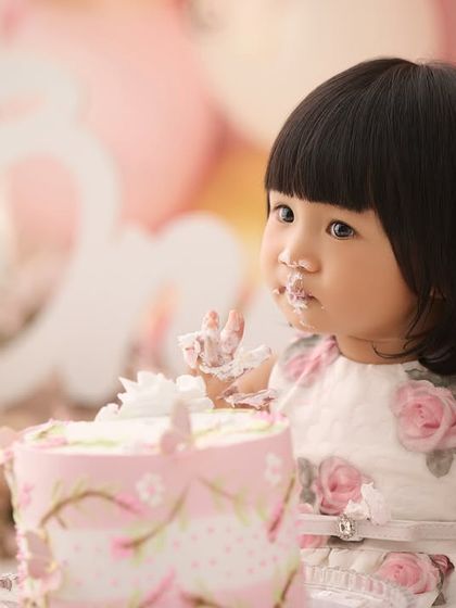 A close-up shot capturing the sweet, frosting-covered details of a first birthday cake smash. These are the little moments you will want to remember forever.