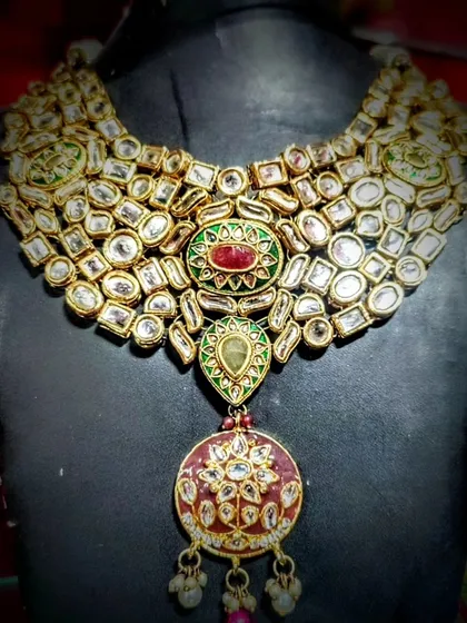 This stunning Polki wedding necklace is the epitome of royal elegance. Crafted by artisans from Bikaner, it features intricate details and uncut stones that give it an authentic, heirloom quality, perfect for your most special occasions.