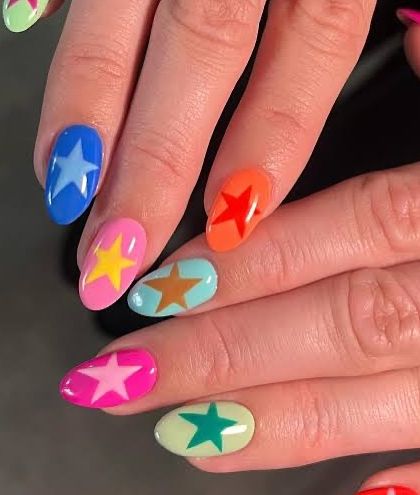 A fun and colorful design for summer. We painted each nail a different bright color and added a contrasting star for a look that is playful and eye-catching.