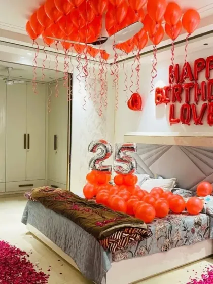 Another angle of the romantic red-themed bedroom setup, showing the pathway of rose petals leading to the bed.
