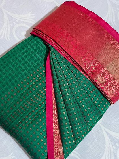 This emerald green saree with a red border is a classic combination. The pleats are done to ensure a graceful fall.