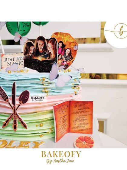 A close-up of the "Just Add Magic" themed cake, showing the edible recipe book and other magical details. The flavor was fresh fruit.