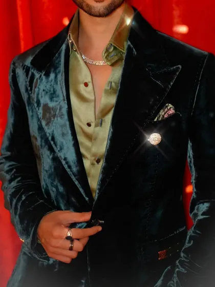 A close-up of our deep green velvet tuxedo, worn by Jainam Vora. The finely detailed buttonhole stitch is a testament to the sophistication and style of the piece.