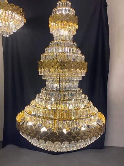 This large, multi-tiered crystal and gold chandelier is a true showstopper. Designed for hotel lobbies and grand villas, its impressive scale and intricate detailing make an unforgettable statement of opulence.