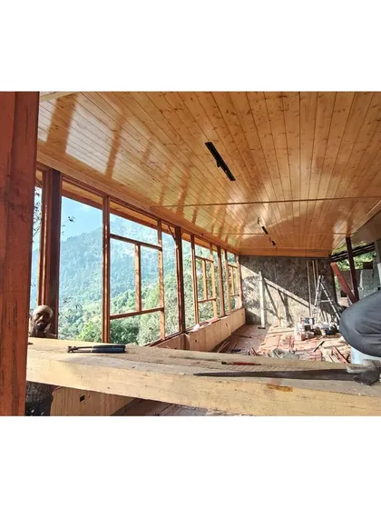 A view from inside the pavilion during construction. The butterfly roof and extensive glazing were crafted to create a space that feels both sheltered and completely open to the surrounding nature.