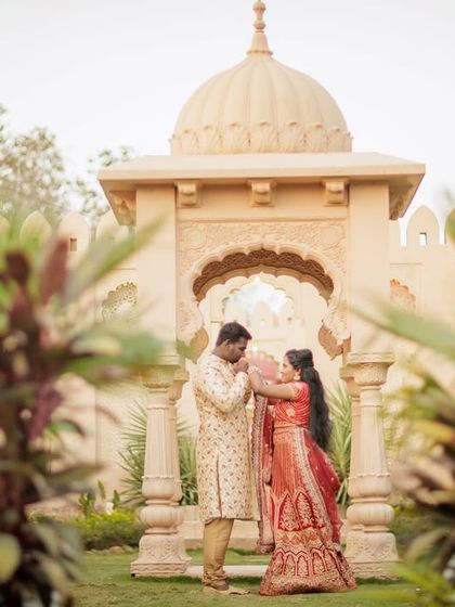 A tender moment in a palace garden, framed by a beautiful stone gazebo. This combines the grandeur of the location with the intimacy of the couple.
