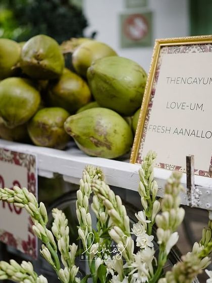 A fresh coconut water cart, or "coco bar," at a Kerala-themed wedding, offering a refreshing and traditional welcome to guests.