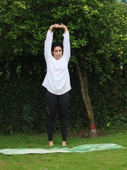 Leading the group in a standing stretch to open up the shoulders and lengthen the spine. It's a simple, powerful way to energize the body.