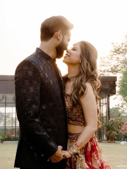 An intimate pre-wedding portrait, with the couple close together, their faces softly lit by the setting sun.