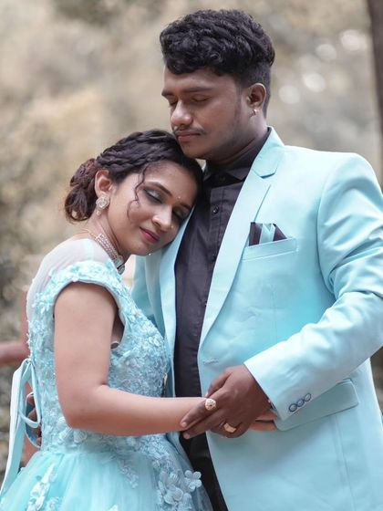 An intimate close-up showing the tender connection between the couple. The delicate floral details on the bodice of the light blue gown are visible here.