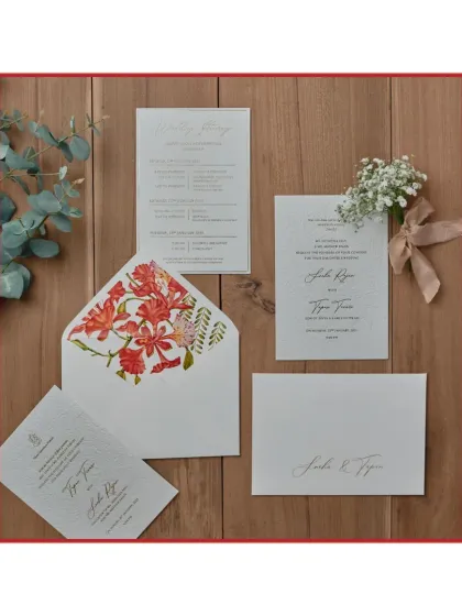 The understated elegance of letterpress printing is truly special. For this suite, we used a blind letterpress technique to emboss a delicate floral pattern, complemented by a vibrant, hand-painted gulmohar flower design on the envelope liner.