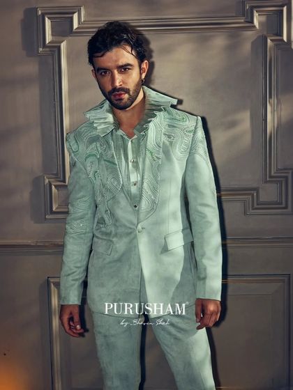 The Muse, captured in a glow of moonlight. This mint green suit features intricate, flowing embroidery and a unique collar, designed to make every moment timeless. This is how you own the stage.