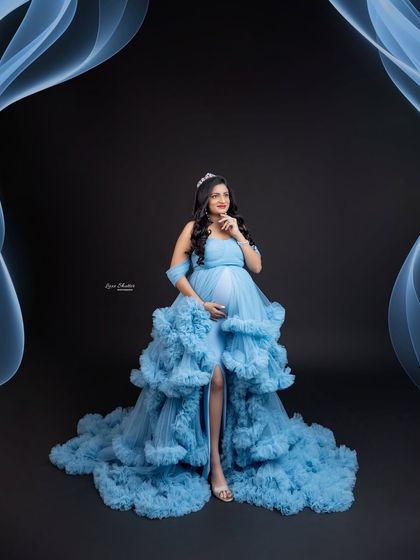 A dreamy, ethereal portrait in a stunning ruffled blue gown. The added smoke and tiara create a fantasy-like atmosphere, perfect for a queen awaiting her little prince or princess.