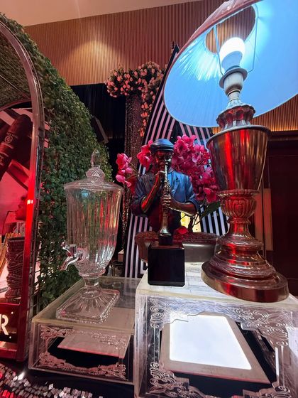 A detailed shot of our bar decor, featuring a saxophonist statue, a vintage lamp, and a glass beverage dispenser.