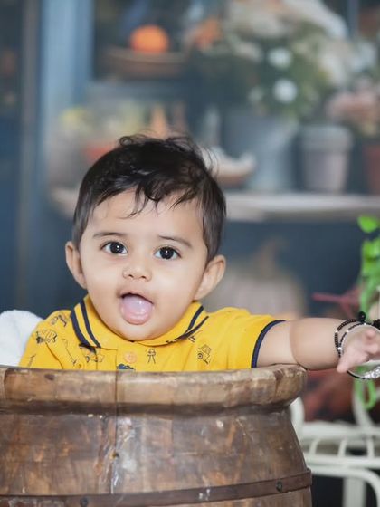 This little boy is enjoying his time in a wooden barrel at the market.