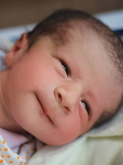 A beautiful close up of a newborn's face, with their eyes just starting to open. Capturing these early expressions is one of my favorite parts of a hospital newborn shoot.