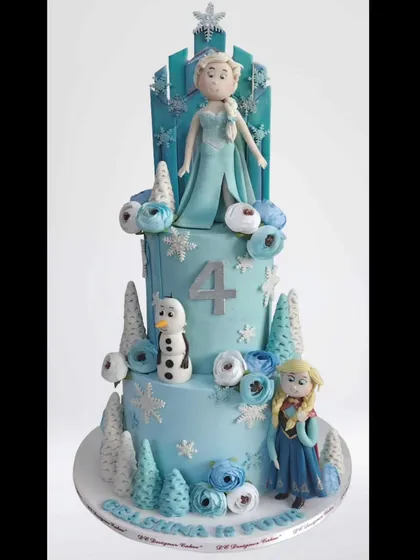 A three-tier Frozen-themed cake featuring Elsa, Anna, and Olaf. This detailed whipped cream creation is perfect for a winter wonderland party, complete with edible snowflakes and frosted trees.