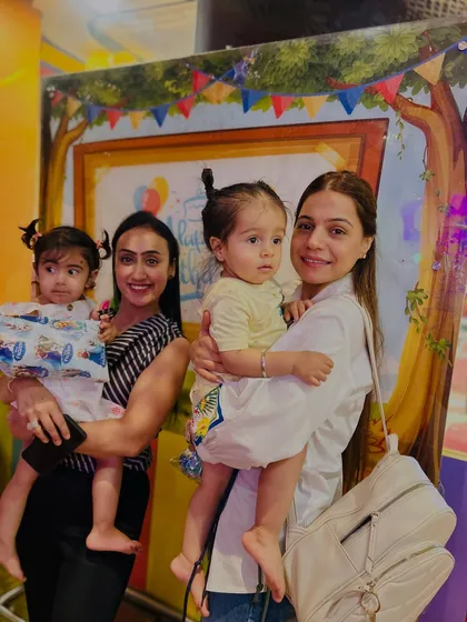 Two moms and their little ones pose together. The friendships formed here often extend to the whole family.