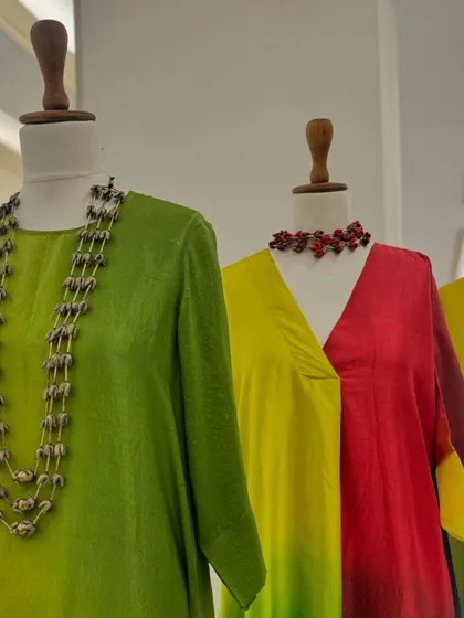 A closer look at the vibrant ombre tunics, each paired with a statement necklace that complements its unique color story.