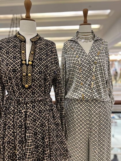 Two stylish monochrome outfits, one a belted dress and the other a sleeveless jumpsuit, perfect for a chic, modern wardrobe.