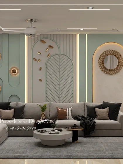 A living room designed with a soothing sage green palette and gold accents. The wall features a mix of textures, including vertical fluting and decorative panels, creating a rich and layered look.