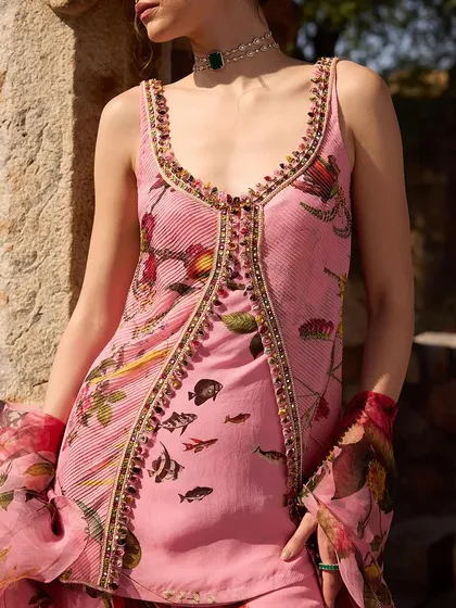 A close-up of a pink printed top with a beautifully embellished neckline, showcasing the fine details of the design.