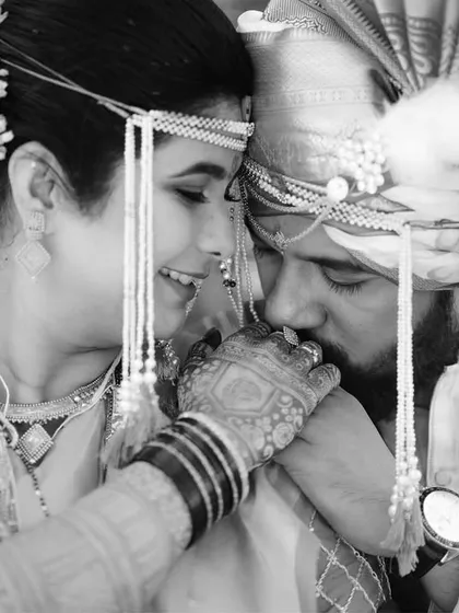 A gentle, intimate moment captured in timeless black and white. The groom kissing the bride's hand is a classic gesture of love that we framed to highlight the intricate mundavalya and henna details.