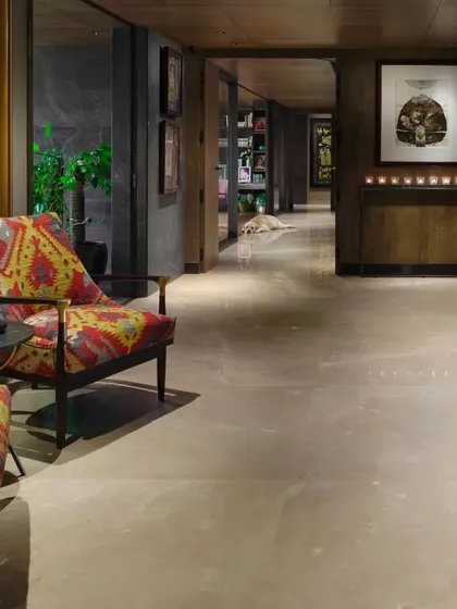 A view down the transformed entrance lobby of the Caitriona apartment, where curated art and lighting create a gallery-like feel. The design uses rich materials and textures to add depth and sophistication to the space.