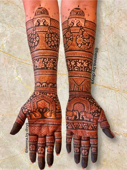 A grand design fit for the groom's mother. This full-arm mehendi features traditional motifs like swans, elephants, and peacocks, telling a story from the palm to the elbow.