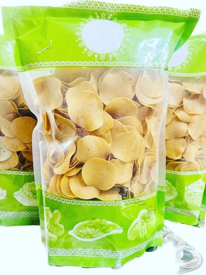 A fresh batch of Masala coin papads, showing their golden color. Just fry them for a few seconds in hot oil, and you have a delicious, crunchy snack ready to eat.