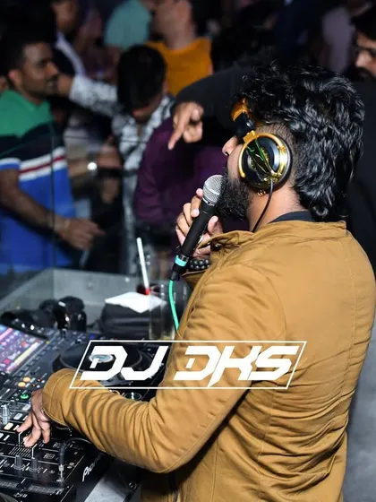 A great DJ does more than just play music. I get on the microphone to interact with the crowd, host segments, and build excitement, ensuring the energy never drops. This is me engaging with the audience during a high-energy set.