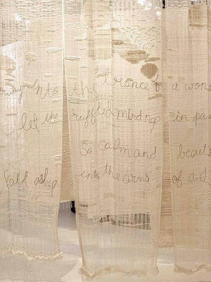 A detail from the 'Sleep Sense' installation, where poetic text is stitched into layers of soft, deckled-edge fabric panels. The running stitch is reminiscent of traditional quilts (rajais), and the backlit panels feel like light, floating clouds in a soothing dream.
