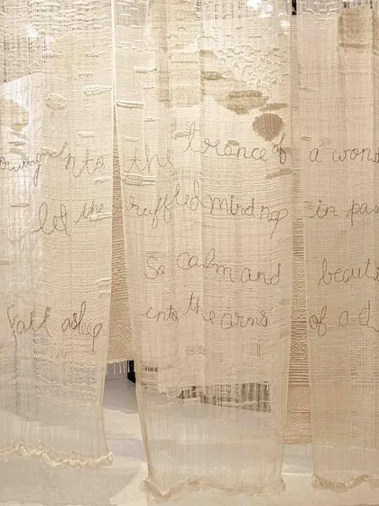 Hand-stitched text on translucent fabric from the 'Sleep Sense' installation. The running stitch is reminiscent of traditional quilts (rajais), adding a layer of warmth and nostalgia to the piece.