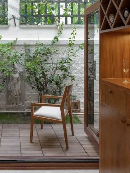 A classic upholstered teak chair, comfortable for use at a study desk or as an occasional chair. Here it is pictured in a client's home, bridging the indoor and outdoor space.