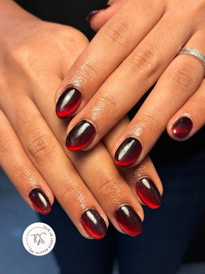 A striking black and red ombre cat-eye effect. The magnetic polish is manipulated to create a smooth transition from deep black to a fiery red tip.