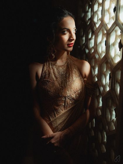 A beautifully composed shot of Tessa by the window. The play of light and shadow accentuates her sculpted features and the richness of her red lipstick.