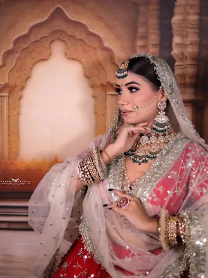 A side profile of the bride, highlighting her elaborate earrings and the delicate texture of her dupatta.