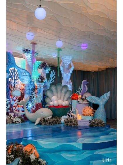A side view of the stage, highlighting the mermaid statues, whale props, and a giant clamshell. Every element is custom-designed to contribute to the underwater fantasy.