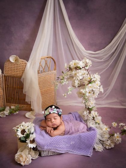 Dreaming in a field of lavender. The purple and white floral arrangement, combined with the sheer curtains, creates a beautiful, ethereal, and royal setting.