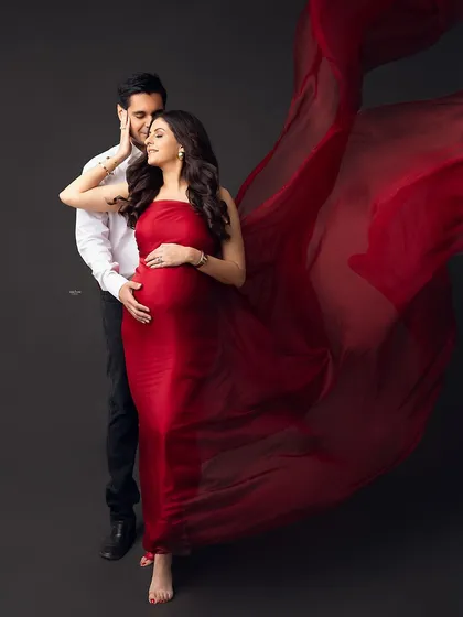 Let's create some magic. For this dramatic maternity portrait, we used a flowing red fabric against a dark backdrop to create a powerful and artistic image that celebrates the beauty of pregnancy. This is for the mamma who wants to feel like a star.