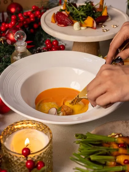 A guest enjoys our handcrafted ravioli in a rich tomato sauce, capturing the fine-dining experience our dinner boxes bring to your home.