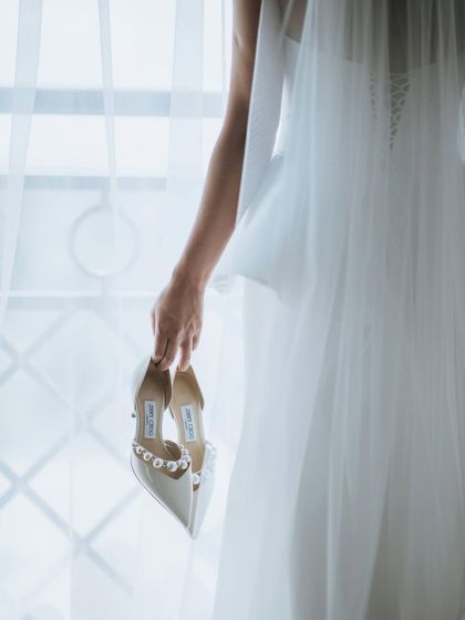 The shoes that will walk her down the aisle. This artistic shot focuses on the bridal shoes, a symbol of the journey she is about to begin.