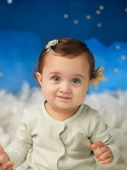 A close-up of this little star, her bright eyes and sweet expression stealing the show. Sitter sessions are ideal when your baby can sit up but isn't crawling yet.