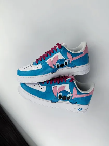 Another view of the Stitch custom sneakers, showing him playfully interacting with the Nike swoosh.