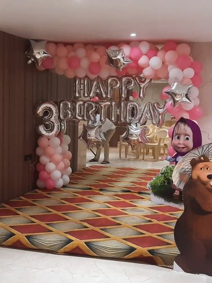 A Masha and the Bear themed 3rd birthday party. The large balloon display and character cutouts at the entrance create an exciting welcome for the little guests.