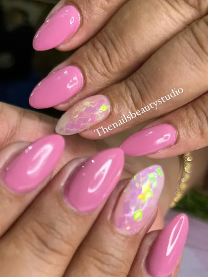 A close-up of these bright pink nails with iridescent shattered glass flakes on the accent fingers.