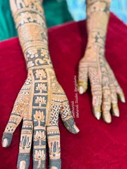 A detailed shot of the finger work in this NRI bridal design, with delicate lotus patterns covering each finger.